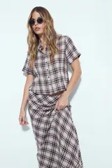 Falda larga de silueta fluida con estampado a cuadros en tonos marrones y beige. La prenda tiene una caída liviana y un calce cómodo.