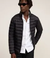 Campera puffer negra ultraligera de poliamida, con cuello alto, cierre por cremallera, bolsillos con cremallera e incluye bolso de almacenamiento.