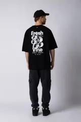 Remera color beige de corte oversize, con cuello redondo y mangas cortas. Estampa pequeña en el frente con la frase "Fresh from the vine".