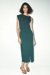 Vestido midi verde oscuro de cuello redondo y sisa americana. Presenta un drapeado en el lateral con detalle de hebilla metálica y abertura en la falda.