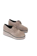 Zapatos oxford color visón confeccionados en gamuza, con plataforma uniforme, perforado decorativo y puntera en alas.