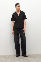 Camisa de manga corta color ciruela, con cuello camisero y cierre frontal de botones.