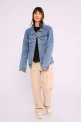 Campera de jean celeste con cuello clásico, cierre frontal con botones metálicos, bolsillos con solapa en el pecho y mangas largas con puños abotonados.