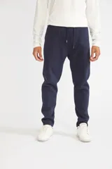 Pantalón deportivo negro con frisa, bolsillos y logo estampado, de fit regular.
