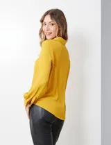 Camisa amarilla de crepe con cuello con solapa, escote en V y abertura central con botones. Delantera fruncida.