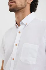 Camisa celeste de manga corta con cuello abotonado y bolsillo en el pecho.