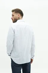 Camisa de manga larga para hombre, color blanco con rayas verticales finas en tonos grises y azules. Confeccionada en una mezcla de lino y algodón, de corte semi slim y logo bordado en el pecho.