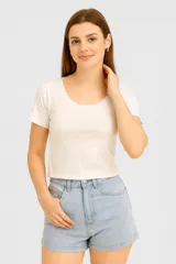 Top cropped blanco de algodón, ajustado al cuerpo y con cuello redondo.