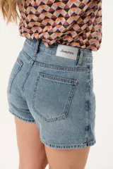 Minifalda de jean azul claro con corte evasé, detalle de short interno y cinturón negro con argollas metálicas.