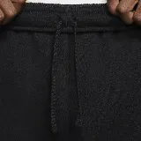 Pantalón de jogging negro de corte ajustado con puños elásticos, bolsillos laterales y bolsillo cargo con solapa en el muslo derecho. Logo de Nike bordado en blanco en el muslo izquierdo.