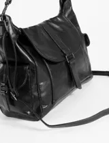 Cartera tipo hobo de cuero vegano color negro, con tapa frontal, cierre de hebilla central y bolsillos laterales con cierre.