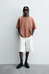 Camiseta color beige de corte holgado, cuello redondo y manga corta.