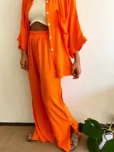 Pantalón largo de corte amplio en color naranja, con cintura elástica y detalles de costura.