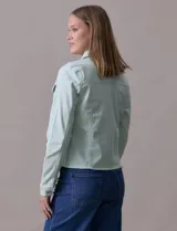Campera de jean blanca, marca Baccini, con cuello solapa, bolsillos delanteros, abertura central con botones metálicos y terminación desflecada en el ruedo.