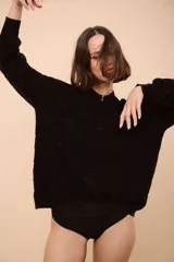 Campera con cierre frontal, de tejido con ondas y rayas horizontales verdes, rojas y negras.