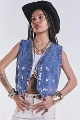Chaleco de jean celeste con bordados y apliques plateados.