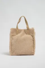 Bolso de sherpa color beige, con asas cortas y diseño acolchado.