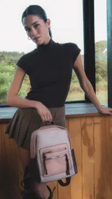 Mochila combinada en tonos beige, rosa y bordó, con apertura superior y dos bolsillos frontales con cierre metálico. Incluye bolsillos laterales y tres bolsillos internos. Tiene correa larga regulable y correas de espalda regulables.
