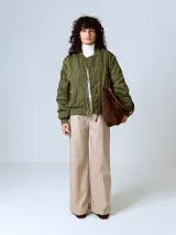 Campera bomber negra de nylon levemente acolchada con hombros caídos y corte holgado.