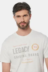 Remera de manga corta color borgoña con cuello redondo y estampado frontal con la leyenda "Legacy Original Brand" en color gris y un círculo con el número "1972" en azul.