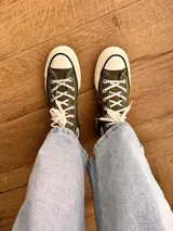 Zapatillas de lona blancas de caña alta con cordones y puntera de goma. Logo de durazno engomado en la base y en la cara interna.