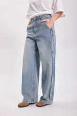 Pantalón jean celeste de corte ancho con detalle de franja lateral azul oscuro.