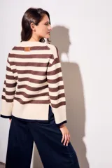 Sweater de punto a rayas horizontales negras y crudas, con cuello redondo y mangas largas. Tiene ribete marrón en puños y ruedo.