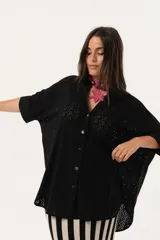 Camisa negra de tejido calado, con escote en V, abotonada y manga 3/4.