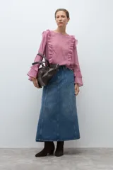 Blusa de manga larga color rosado con textura, escote redondo y volados decorativos en los hombros y a lo largo del frente.