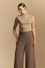 Top sin mangas negro, con cuello alto y hombros ligeramente estructurados. El tejido presenta una textura sutil con brillo integrado que simula un animal print.