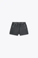 Shorts de tiro alto confeccionados en tejido con efecto lavado, cintura elástica ajustable con cordones, bolsillos laterales de vivo y tejido combinado en rib a tono.