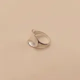 Anillo de plata 925 con una gran piedra ovalada transparente y una banda con pequeños cristales.