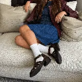 Sandalias franciscanas de cuero color marrón con tiras entretejidas, hebilla lateral y taco bajo de madera.