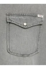 Camisa de denim gris de manga larga, con cuello clásico, cierre frontal con botones a presión y dos bolsillos con solapa abotonada en el pecho.