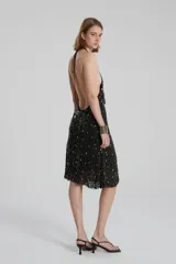 Vestido negro con lentejuelas brillantes, de corte suelto y tirantes finos.