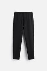 Pantalón negro de corte cropped, con cintura elástica ajustable con cordón, bolsillos laterales y traseros de vivo. El bajo tiene terminación con vuelta.