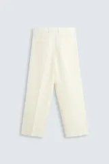 Pantalón color crema de lino, corte relaxed fit, con pliegues frontales, bolsillos laterales y traseros de vivo.