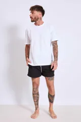 Short de baño color marrón con cordón ajustable en la cintura y logo estampado en blanco en la pierna izquierda.