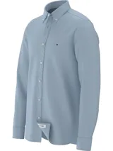 Camisa celeste de Tommy Hilfiger, corte slim, confeccionada en tejido dobby de algodón orgánico con tecnología TH Flex, cuello abotonado, mangas largas con puños redondeados con dos botones y logo bordado en el pecho.
