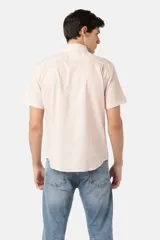 Camisa manga corta color rosa claro, con cuello clásico, cierre frontal con botones y bolsillo en el pecho.