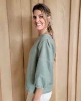 Blusa de manga larga, color beige y blanco, con pespuntes contrastantes y un corte suelto.