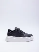Zapatillas acordonadas de color negro con base de plataforma blanca, ideales para looks casuales.