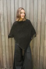 Poncho tejido en hilo de algodón con lurex color negro y dorado, con flecos en el ruedo.