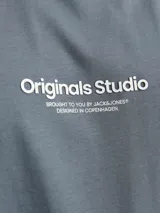 Remera azul grisáceo de manga corta con cuello redondo y corte relajado. Diseño con estampa frontal con texto en color blanco.