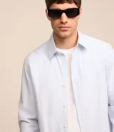 Camisa de hombre regular, de sastrería rayada celeste y blanco, con cuello solapa, abotonada y de manga larga.