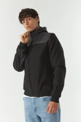 Campera softshell verde con capucha removible, cierre frontal y bolsillos con cierre.