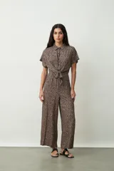 Mono largo negro de corte palazzo con camisa de mangas cortas con botones y lazo en la cintura.