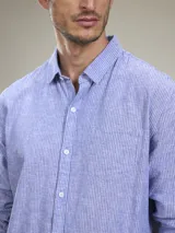 Camisa verde militar de manga larga, confeccionada en mezcla de lino y algodón. Tiene cuello clásico, cierre con botones y un bolsillo en el pecho.