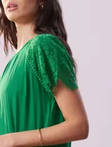 Remera verde de modal con cuello redondo y manga corta con aplique de encaje.