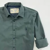 Camisa de cuello italiano en algodón de alta calidad con estampado a cuadros pequeños en tonos de verde. Tiene mangas largas con puños abotonados y logo bordado en el pecho.